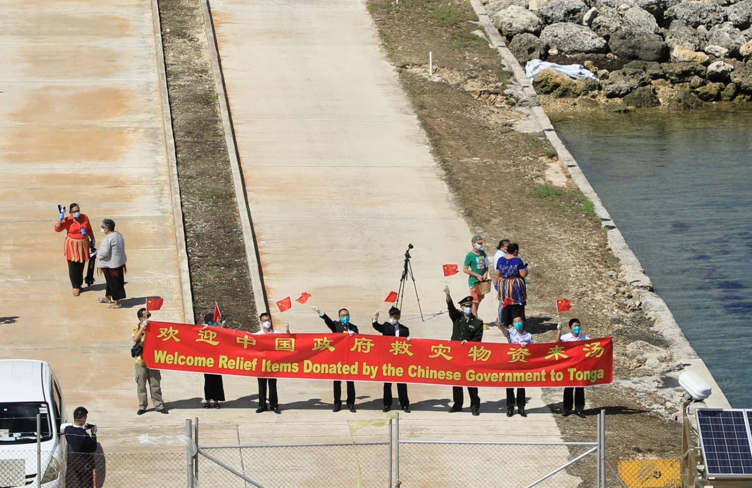 Staff from the Chinese Embassy in Tonga welcome a flotilla of the People's Liberation Army Navy delivering relief supplies in Nuku' alofa, Tonga, 15 February 2022 (Xue Chengqing/Xinhua via Getty Images)